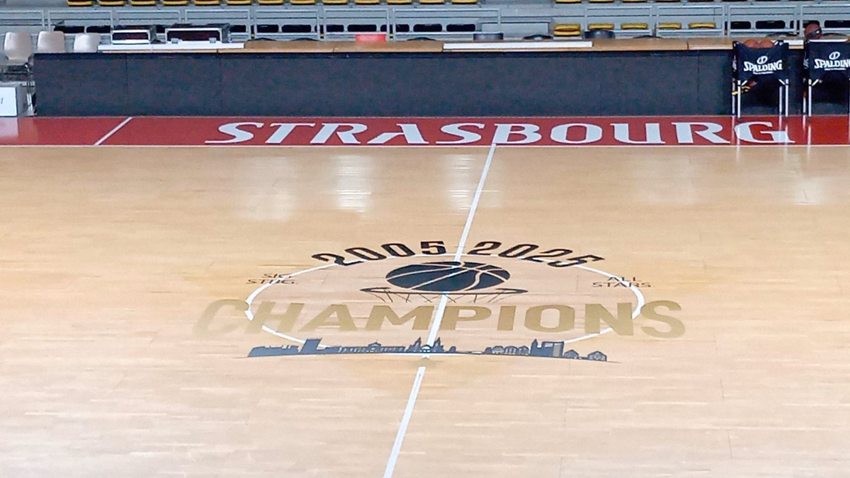 Vinilo de círculo central en una cancha de baloncesto vacía vista desde la grada